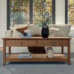 a living room with couch, coffee table and windows