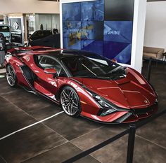 a red sports car on display in a showroom