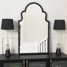 a large mirror sitting on top of a black dresser