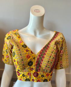 A yellow color embroidered blouse  Product details Fabric -Georgette Embroidery - Silk threads and sequins Bust size 38" Waist 30" Sleeve length  10" Can be tailored to fit 40" For extra charges Yellow Choli With Floral Embroidery For Reception, Bollywood Style V-neck Top With Resham Embroidery, Fitted Yellow Embroidered Fabric For Reception, Fitted Multicolor Embroidered Top With Intricate Embroidery, Fitted Multicolor Embroidered Top, Bollywood Style Embroidered V-neck Top, Yellow Embroidered Fabric For Festive Reception, Party Yellow Embroidered Choli, Yellow Long Sleeve Choli For Wedding