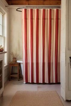 a bathroom with a red and white shower curtain