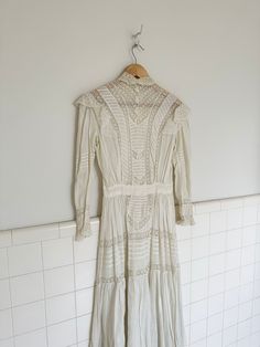 an incredibly beautiful long sleeve lawn dress in a creamy white. features paneled lace windows throughout bodice, sleeve and skirt. intricate lace ruffle trim on the shoulder, sleeve hem and collar. hidden button closures down the back. no interior tags but my best guess would be that it's from early 1900s. in AMAZING condition for age- one small rust stain on shoulder lace ruffle and some small pin holes on small of back where exposed buttons are. see all pictures for detail and use zoom feature for closeup.  measurements are taken with garment lying flat  bust 38' waist 26' sleeve 20' shoulder 7.5' length 49.5' Lace Window, Lawn Dress, Wedding Rituals, Small Pin, Lingerie Dress, Lace Ruffle, Early 1900s, Phoenix Az, Creamy White