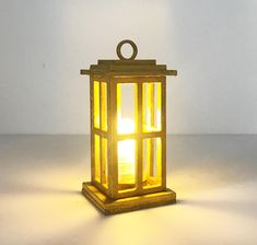 a yellow lantern is sitting on the floor with light coming from it's top