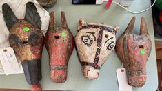 three wooden masks are sitting on a table