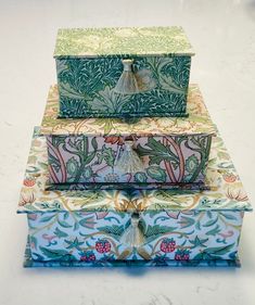 three decorative boxes are stacked on top of each other