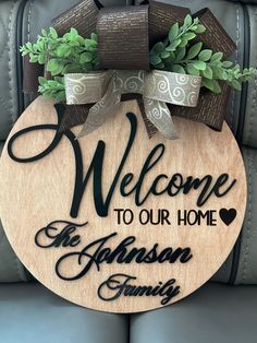 welcome to our home sign hanging on the back of a chair with potted plants