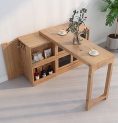 a wooden table with two shelves on the side and a potted plant next to it