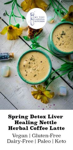 two bowls filled with liquid sitting on top of a wooden table next to flowers and herbs