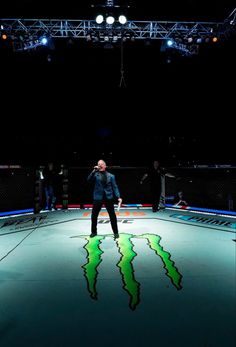 a man standing on top of a green and black floor in front of a crowd