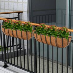 two planters with flowers in them are on the balcony railing, along with a black iron hand rail