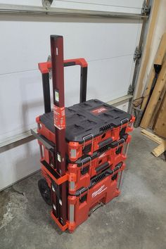 a red and black tool box sitting on top of a floor