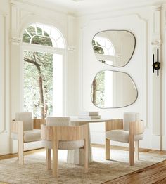 a living room with two chairs and a table in front of a large mirror on the wall