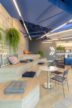 the interior of an office building with plants on the wall and tables in the center