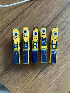 four minion erasers sitting on top of a wooden table