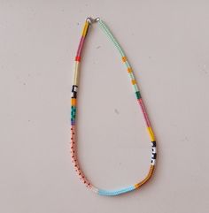 a multicolored beaded necklace on a white surface