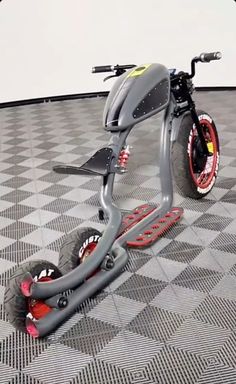 a scooter sitting on top of a checkered floor in an empty room