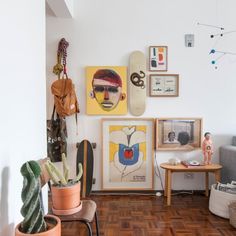 a living room filled with furniture and pictures on the wall next to a wooden floor