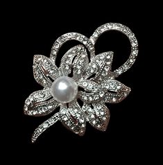 Very beautiful openwork brooch in the shape of flowers in new silver color of openwork quality Art Deco spirit set with "rhinestone diamonds" and set with its large pearly white pearl collection. Solid clasp see supporting photos. This flower-shaped jewel brooch in the old spirit will seduce you with its certain charm and its Art Deco side. Perfect for making an original and unique gift or to expand your personal collection. As a gift a small box bag. Dimensions: Length: 5.5 cm Width: 4 cm Price Elegant Flower Pendant Brooch Jewelry, Elegant Flower Pendant Brooch, Ornate White Gold Brooches For Wedding, Ornate White Gold Wedding Brooches, Elegant Diamond White Brooches For Wedding, Elegant Diamond White Wedding Brooches, Elegant Filigree Brooches For Evening, Elegant White Filigree Brooches, Flower Pendant Brooch For Wedding