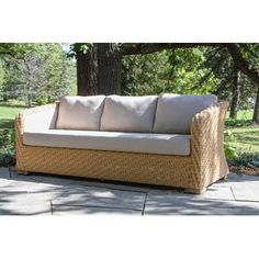 a wicker couch sitting on top of a sidewalk