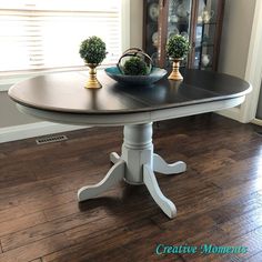 a dining room table with two potted plants on it