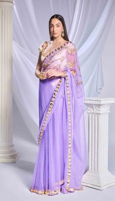 Introducing our lilac saree, crafted from a blend of tulle and organza fabrics. It features a dainty embroidered organza pallu adorned with intricate floral motifs made of sequins, metallic leaves, and cut dana. The pre-stitched tulle bottom features a refined gold border and acrylic motifs running along the hem. Paired with an ivory georgette blouse, embellished with metal circles, pearl embroidery, and delicate cutwork detailing throughout.From Papa Don’t Preach’s Bring Your Own Fairytale collection. DELIVERY TIMEPlease allow 8-12 weeks for your outfit to arrive. FABRIC DETAILSOrganza Professional cleaning only. Elegant Purple Tissue Silk Pre-draped Saree, Purple Chanderi Pre-draped Saree For Reception, Elegant Purple Chanderi Pre-draped Saree, Purple Chanderi Pre-draped Saree For Wedding, Festive Purple Pre-draped Saree For Wedding, Purple Pre-draped Saree With Dupatta For Reception, Purple Organza Pre-draped Saree With Dupatta, Purple Organza Pre-draped Saree For Diwali, Elegant Lavender Dupatta For Reception