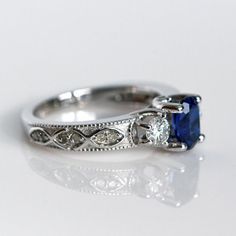 an engagement ring with a blue sapphire stone in the center and two diamonds on each side