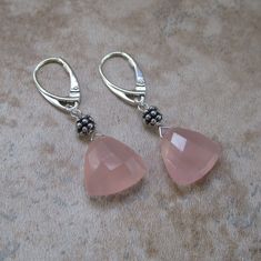 These pink chalcedony earrings are nothing less than gorgeous. The earrings are neither too small, nor too large. And they are ultra-feminine and lovely. They feel so good on! *Pink chalcedony trillion-cut (triangular) stones: .5 inch *Accents: Sterling-silver beads  *Ear wires: Sterling silver lever back *Approximate earring length: 1.75 inches. Elegant Nickel-free Rose Quartz Earrings, Trillion Cut Earrings, Pink Chalcedony, Chalcedony Earrings, Chalcedony Stone, Sterling Silver Bead, Earrings Silver, Stone Earrings, Silver Beads