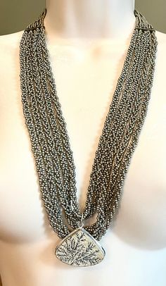 I made this Handmade braded seed bead and German Dendrite and silver Artsy / Boho necklace. It can be worn long or shorter. measures 24", but also has a generous extender. Silver Long Beaded Necklace With Polished Beads, Silver Polished Beaded Long Necklace, Silver Polished Long Beaded Necklace, Silver Multi-strand Bohemian Beads, Silver Bohemian Multi-strand Beads, Silver Lariat Necklace With Polished Beads, Adjustable Silver Beaded Necklace With Large Beads, Silver Multi-strand Beaded Chain Beads, Silver Multi-strand Beaded Jewelry