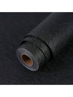 a roll of black fabric on a white background