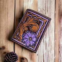 100% handmade tooled leather card holder. Card holder features one of a kind hand tooling with bright lilac purple accents, lined purple interior with 2 card holders on the inside, 1 purple exterior card pocket, and a magnetic closure. Three card pockets total. Perfect for on the go when you don't want to carry a large wallet or purse! Holder measures 3" x 4" Brown Hand Tooled Trifold Wallet As Gift, Handmade Artisan Trifold Wallet, Artisan Hand Tooled Bifold Wallet, Artisan Hand-tooled Bifold Wallet, Purple Leather Wallet For Gift, Purple Leather Wallets For Gifts, Purple Leather Wallet As Gift, Purple Leather Wallet As A Gift, Hand Tooled Brown Wallets As Gift