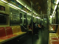 people are sitting on the subway train with their backs to each other