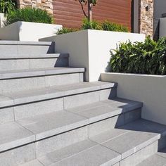 concrete steps with planters on them in front of a house