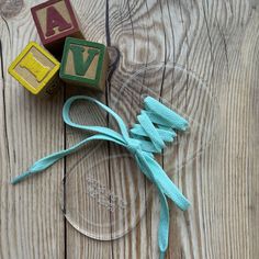 two wooden blocks tied to a string on top of a glass plate with the word love spelled in small letters