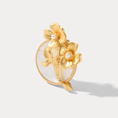 The Evening Primrose Brooch is a captivating piece that embodies the delicate beauty of nature. Made from gold on brass, this exquisite brooch features an imitation pearl. Inspired by the enchanting allure of cottage gardens, it brings a sense of tranquility and natural charm to your everyday wear. As a fine jewelry accessory, it showcases exceptional craftsmanship and quality materials, ensuring its enduring beauty. Let the Evening Primrose Brooch be your symbol of grace and timeless style, emb Elegant Gold Flower Lapel Pin, Elegant Gold Flower Brooches, Elegant Gold Flower Brooch, Gold Flower Brooch Lapel Pin, Gold Flower Brooch Pins, Gold Flower Brooch For Wedding, Gold Flower-shaped Brooch With Floral Decoration, Gold Flower Pins For Wedding, Gold Flower-shaped Wedding Brooches