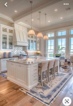 a large kitchen with white cabinets and an island in the middle of the flooring