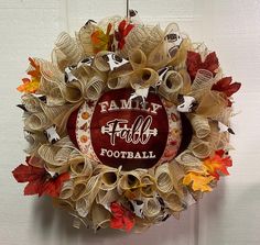 a wreath made out of newspaper strips with the words family football written on it and decorated with fall leaves