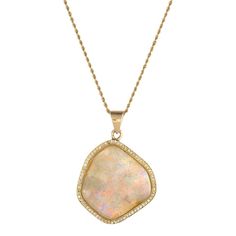 This is part of Chairish’s Fine Jewelry assortment.  Stylish opal & diamond pendant, crafted in 18 karat yellow gold (pendant) and 14 karat yellow gold (chain).    A large natural freeform opal measures 26mm x 24mm and is framed with 75 round brilliant cut diamonds that total an estimated 0.37 carats (estimated at H-I color and VS2-SI1 clarity). The opal is in very good condition and is free of cracks or chips.     The contemporary pendant is designed in a freeform mounting to mirror the shape o Luxury Opal Necklace With 17 Jewels, Opal Pendant Necklace With Large Pendant, Luxury Yellow Gold Opal Necklace, Luxury Opal Pendant Necklace, Elegant Opal Necklace With Large Pendant, Luxury Gold Opal Necklaces, Luxury Gold Opal Necklace, Elegant Opal Jewelry With Large Pendant, Elegant Ethiopian Opal Necklace In Yellow Gold