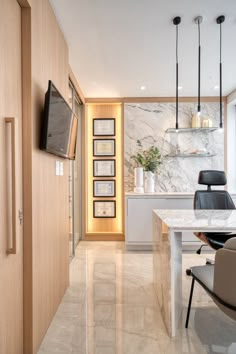 a kitchen with marble flooring and white counter tops next to a tv mounted on the wall