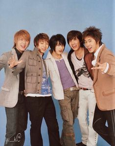 the group of young men are posing together for a photo in front of a blue background