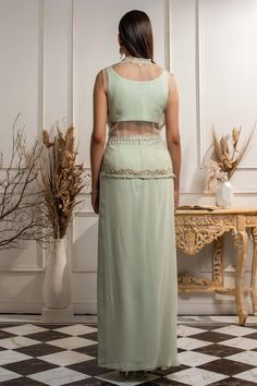 Mint green high-waist lehenga with draped detail and asymmetric hem. Comes with blouse, sheer jacket and waist belt.
Components:4
Embroidery
Neckline:Blouse: Leaf
Sleeve Length:Blouse: Sleeveless; Jacket: Sleeveless 
Fabric:Pure Georgette, Organza
Color:Green
Lining material: Satin
Hand embroidery
Embroidered floral motifs on blouse
Embroidered floral motifs and ruffle detail on jacket border
Embroidered motifs and tassel detail on belt
Closure:
Blouse: Concealed side zip placket
Lehenga: Concea Green Maxi Length Lehenga With Intricate Embroidery, Green Maxi Length Sharara With Intricate Embroidery, Green Maxi-length Sharara With Intricate Embroidery, Green Embroidered Maxi Length Sharara, Fitted Green Choli Of Maxi Length, Fitted Green Maxi Choli, Green Fitted Maxi-length Choli, Fitted Maxi Length Green Choli, Fitted Maxi-length Green Choli