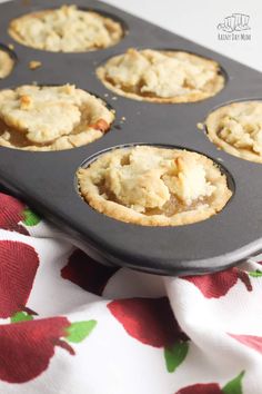 a muffin tin filled with mini pies on top of a table