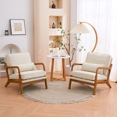 a living room with two chairs and a table in front of a window, next to a lamp