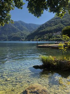 the water is crystal clear and there are mountains in the background