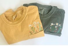 - Details - - This is for 1 short sleeved comfort colors pocket graphic t shirt with embroidered wildflowers.  - Please see size chart and shirt colors in product images. * Unisex t shirt fits like a well-loved favorite, featuring a crew neck, short sleeves and designed with superior airlume combed and ring-spun cotton that acts as the best blank canvas for printing. * Features: Side-seamed. Retail fit. Unisex sizing. Shoulder taping RETURNS/EXCHANGES/CANCELLATIONS * We do not accept returns. This is due to each item is hand crafted and being made-to-order for you. HOWEVER, if there is a problem, PLEASE reach out to us directly so that we can help. * Order Cancellations are accepted for 2 hours after your purchase. * We do accept exchanges if there is a sizing issue. We understand that wit Embroidered Wildflowers, Closet Necessities, Flower Pocket, Wildflower Shirt, Botanical Shirt, Cute Spring, Boho Gifts, Flower Shirt, Shirt Fits