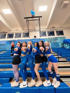 the cheerleaders are posing for a photo on the bleachers