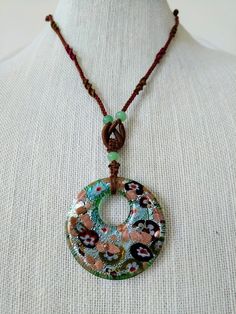 This is a truly unique and beautiful necklace. A colorfully designed glass pendant (approx. 2"x 2") hangs from an intricately hand-knotted string (adjustable from 22" to 29".) This necklace is very versatile -- no matter what color top you wear it with, it makes it easy to match and look outstanding. Adjustable Long Glass Necklace, Adjustable Large Pendant Necklace For Festivals, Handmade Multicolor Necklaces From Recycled Glass, Artisan Adjustable Recycled Glass Necklace, Gift Round Pendant Necklace With Sliding Knot, Adjustable Multicolor Czech Glass Necklace, Turquoise Necklace With Sliding Knot For Gift, Bohemian Adjustable Necklace With Recycled Glass, Adjustable Glass Jewelry With Cord