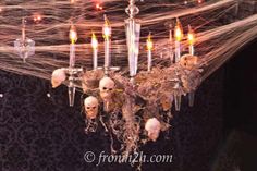 a chandelier with skulls and candles hanging from it