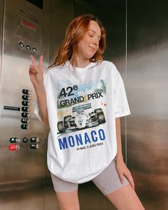 Introducing our Vintage-Inspired Monaco Grand Prix Tee Shirt. Crafted on a Comfort Colors Unisex Tee, this shirt offers the perfect blend of vintage charm, modern comfort, and style. 👕 Comfort Colors Unisex Tee: Made from premium 100% ring-spun cotton, the Comfort Colors Unisex Tee guarantees exceptional softness and comfort. Its relaxed fit and robust construction ensures comfort and durability. Whether you're cheering at the racetrack or lounging with friends, this tee delivers unbeatable comfort. 🕰️ Timeless Style:  Perfect for casual outings, race day gatherings, or expressing your love for F1 🌟 Key Features: Vintage-inspired Monaco Grand Prix graphic. High-quality, soft 100% ring-spun cotton. Comfort Colors Unisex Tee for ultimate comfort. Classic fit suitable for all genders. Uniq Vintage Crew Neck Top With Sublimation Print, Vintage Short Sleeve Top With Sublimation Print, Vintage Short Sleeve Shirt With Sublimation Print, Vintage Crew Neck Shirt With Letter Print, Vintage White Top With Sublimation Print, Vintage White Crew Neck Shirt, F1 Monaco, Monaco Grand Prix, Vintage T Shirts