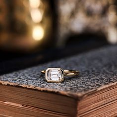 an engagement ring sitting on top of a book