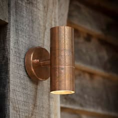 a light that is on the side of a wooden wall next to a door way